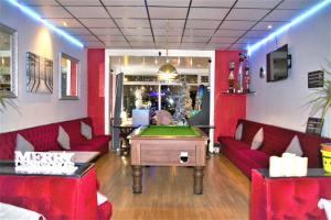 a billiard room with a pool table and red furniture at MyRoomz Silver Strand Hotel in Blackpool