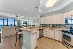 a kitchen with white cabinets and a table and chairs at Phoenix West 1508 in Orange Beach