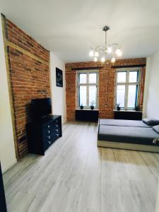 a large room with a bed and a brick wall at LIBERation! in Olsztyn