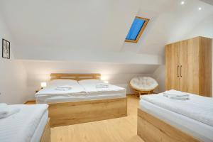 a small bedroom with two beds and a chair at Krušnohorské Stráně in Loučná pod Klínovcem