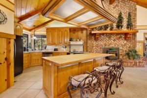 una cocina con armarios de madera y una barra con sillas en 2030-Bearfoot Lodge home, en Big Bear Lake