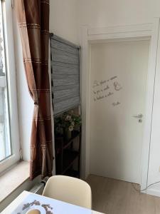 Zimmer mit einem Tisch und einer Tür mit einem Fenster in der Unterkunft Cocon in Jumet