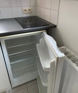 een lege koelkast met de deur open in een keuken bij Cocon in Jumet