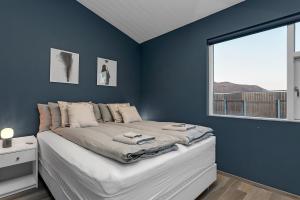 a bedroom with a large bed with a blue wall at The Lava Bowl in Grindavík