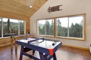 een woonkamer met een pooltafel en ramen bij 2141-Silver Tip Chalet home in Big Bear Lake