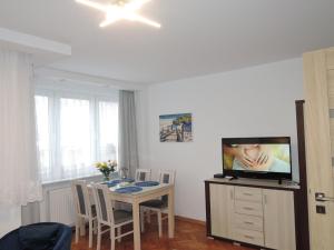 ein Esszimmer mit einem Tisch und einem TV in einem Zimmer in der Unterkunft Holiday flat, Swinoujscie in Świnoujście