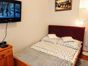 a small bedroom with a bed and a flat screen tv at Holiday flat, Swinoujscie in Świnoujście