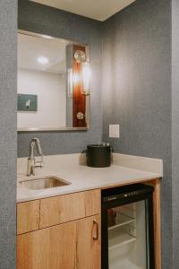 a kitchen counter with a sink and a mirror at Summit Hotel at Big Sky Resort in Big Sky