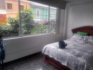 1 dormitorio con cama y ventana en SUITE PB101 - A 5 MINUTOS DEL CENTRO HISTORICO, en Quito