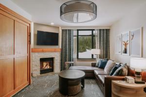 a living room with a couch and a fireplace at Summit Hotel at Big Sky Resort in Big Sky
