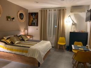 a bedroom with a bed and a table and chairs at LA DI MARIA in Narbonne