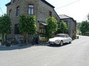a white car parked in front of a brick building at Le Vieux Tribunal in Durbuy