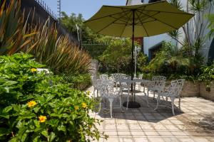 a table and chairs with an umbrella in a garden at Casa Mateo in Guadalajara