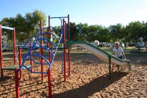 dwoje ludzi bawiących się na zjeżdżalni na placu zabaw w obiekcie Coral Coast Tourist Park w mieście Carnarvon