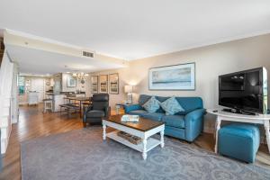 a living room with a blue couch and a tv at Perdido Towers East 104 in Perdido Key