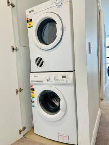 lavadora y secadora en una habitación en Cozy unit close to Parliament w/Amazing City Views en Melbourne