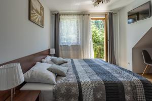 a bedroom with a bed and a window with a view at Pensjonat Pod Długą Polaną in Nowy Targ