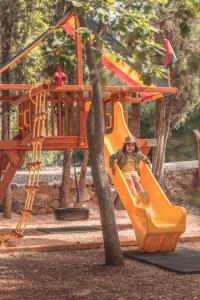 a person sitting on a slide at a playground at Camping la Peiriere in Tuchan
