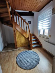 a room with a wooden staircase and a blue rug at Sehr Schönes 2 Zimmer Maisonnette Wohnung in Ansbach