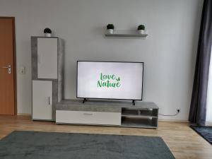 a flat screen tv sitting on a stand in a living room at Sehr Schönes 2 Zimmer Maisonnette Wohnung in Ansbach