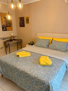 a bedroom with a large bed with two yellow pillows at Cozy studio, 1min from Kamara in Thessaloniki