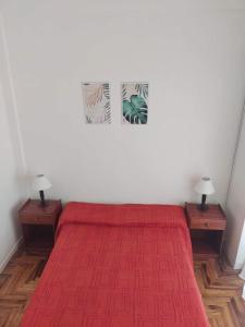 1 dormitorio con 1 cama roja, 2 mesitas de noche y 2 lámparas en Dpto Serafina en Mar del Plata