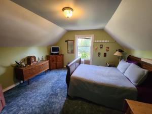 a bedroom with a bed and a dresser and a window at Eugene Lodge and International Hostel in Eugene