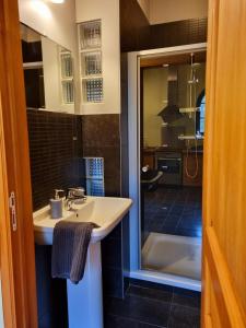 La salle de bains est pourvue d'un lavabo et d'une baignoire. dans l'établissement Gîte de la Ferme de Seron - gîte de charme avec bain nordique, à Fernelmont