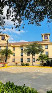 a large building with a parking lot in front of it at Sleep Inn & Suites Bush Intercontinental - IAH East in Humble