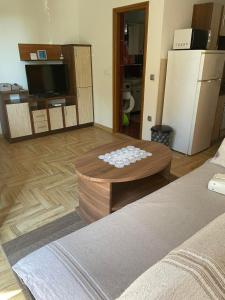a living room with a coffee table and a refrigerator at Apartman Edi in Nin