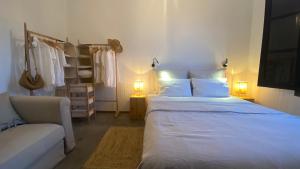 - une chambre avec un grand lit blanc et un canapé dans l'établissement Casa Moni Ferienwohnung mit Meerblick, à Playa de Santiago