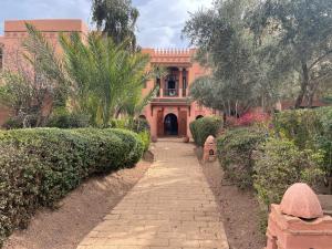 a building with a walkway in front of a building at Au Cœur de la Palmeraie de Marrakech in Marrakech