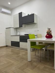 una cucina con tavolo bianco e sedie verdi di Airport security 161 a Napoli