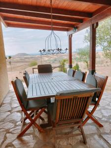 einen Holztisch und Stühle auf einer Terrasse mit Aussicht in der Unterkunft Puerta Laguna - Casa con parcela in Hita