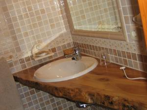 a bathroom with a sink and a mirror at Hotel Rural El Museo in Cedillo de la Torre