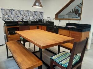 cocina con mesa de madera y 2 sillas en HS Residence 1, en Itacaré