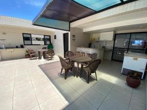 un patio con tavolo e sedie e una cucina di Apart. Dois quartos na Ponta Verde a Maceió