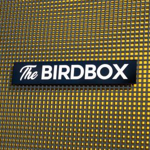 a black and white sign on a yellow wall at The Birdbox - Unique Cabin in Millport in Millport