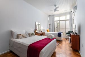 um quarto com uma grande cama branca e um sofá em Sossego em Ipanema - Ideal para famílias - VP101A Z2 no Rio de Janeiro