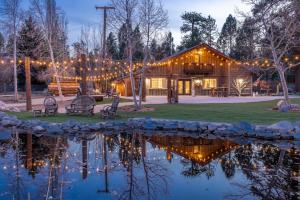 ein Blockhaus mit einem Teich davor in der Unterkunft 1999-Shay Meadows Ranch and Resort home in Big Bear City