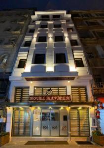 un bâtiment blanc avec un magasin devant lui dans l'établissement Hotel Mavirem, à Istanbul