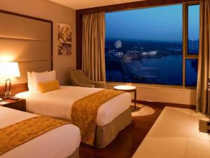 a hotel room with two beds and a large window at Crowne Plaza Kochi, an IHG Hotel in Cochin