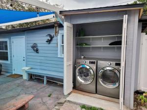 - un lave-linge et un sèche-linge à l'extérieur d'une maison bleue dans l'établissement Enchanting & Welcoming 2 Bedroom Apartment-POLK #1, à New Port Richey