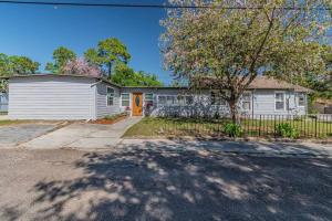 a house with a white garage and a fence at Enchanting & Welcoming 2 Bedroom Apartment-POLK #1 in New Port Richey