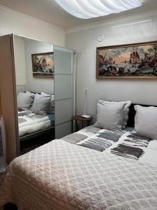 een slaapkamer met 2 bedden en een spiegel bij Villa Baroque in Pierrefitte-sur-Seine