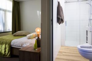 una camera con letto e un bagno con lavandino di Hotel Old Dutch Bergen op Zoom a Bergen op Zoom