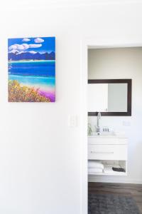 a bathroom with a painting of the ocean at River View Collingwood in Collingwood