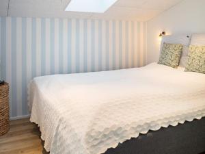 a bedroom with a large white bed with striped walls at Holiday home Thisted LIII in Thisted