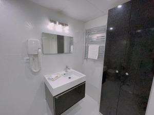 a white bathroom with a sink and a shower at Piso Atares Calle Alfonso in Zaragoza