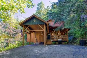 a cabin in the woods with a driveway at Cozy Cabin with Mountain Views Near SkyLift Park! in Gatlinburg